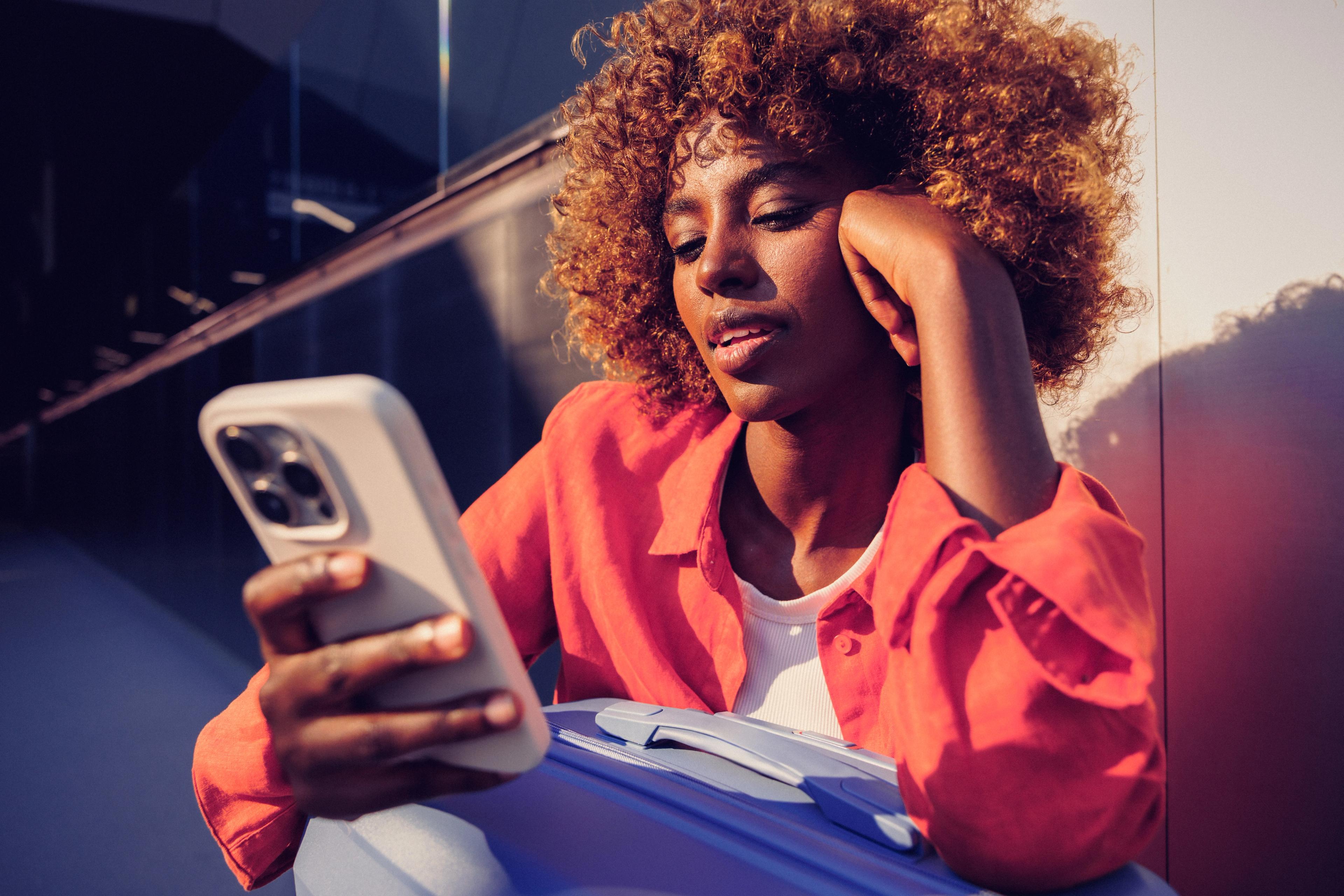 Woman resting her head on her hand as she reads her phone