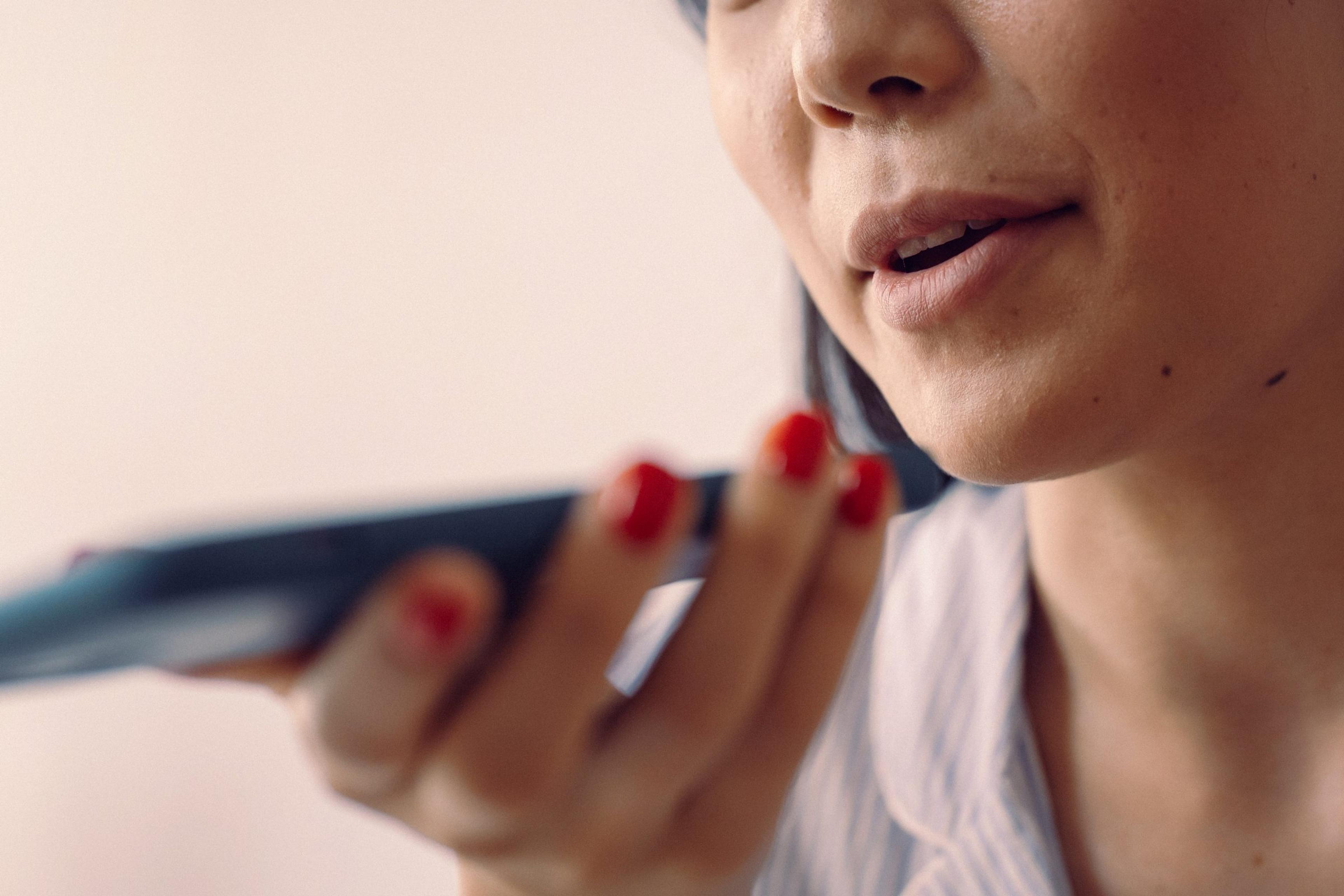 Woman speaking into a phone held close to her face