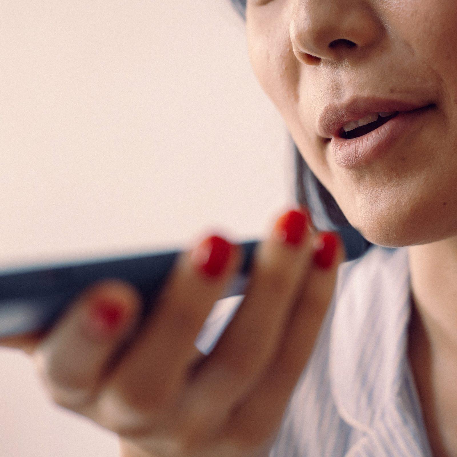 Woman speaking into a phone held close to her face
