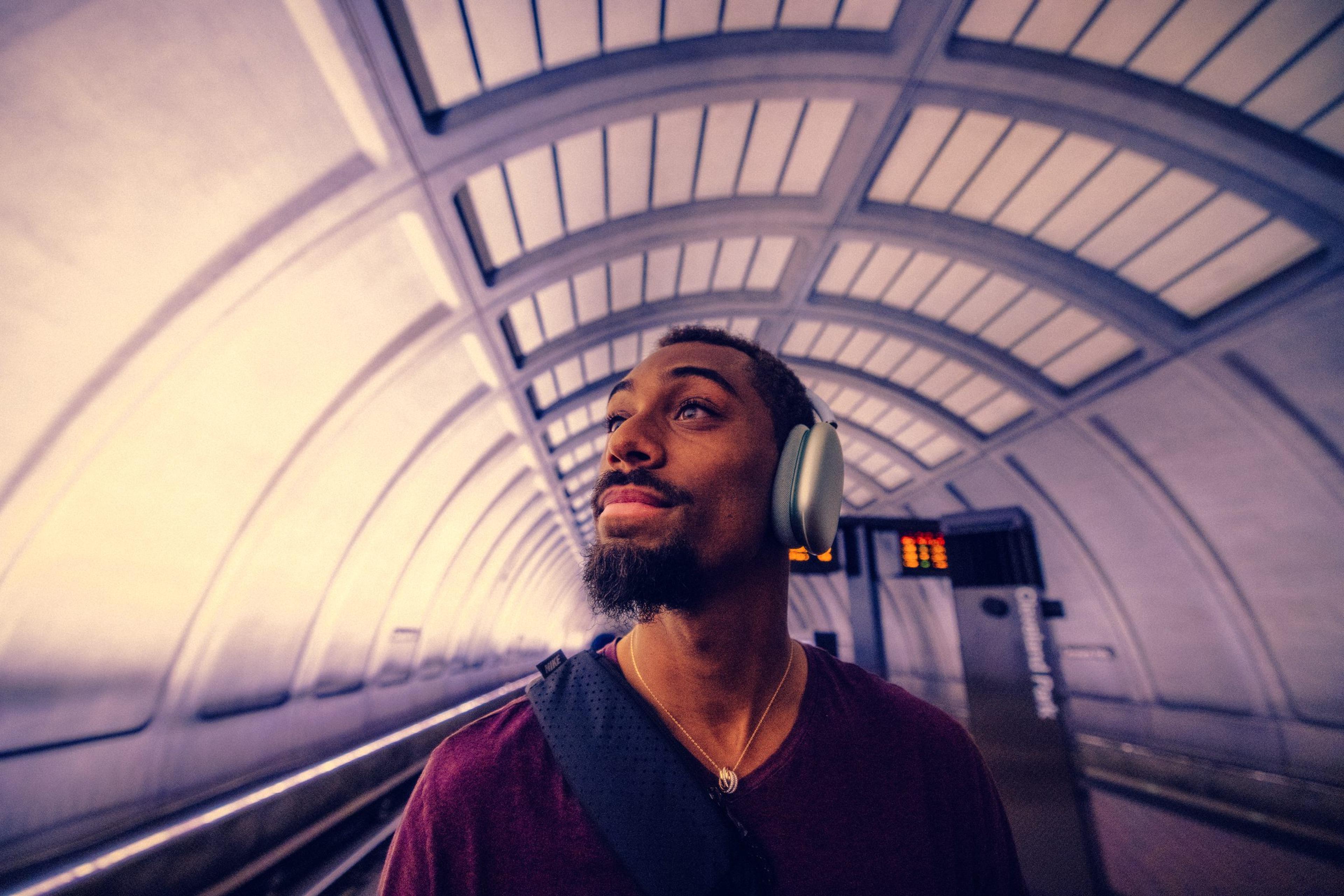 Man wearing headphones on a subway platform