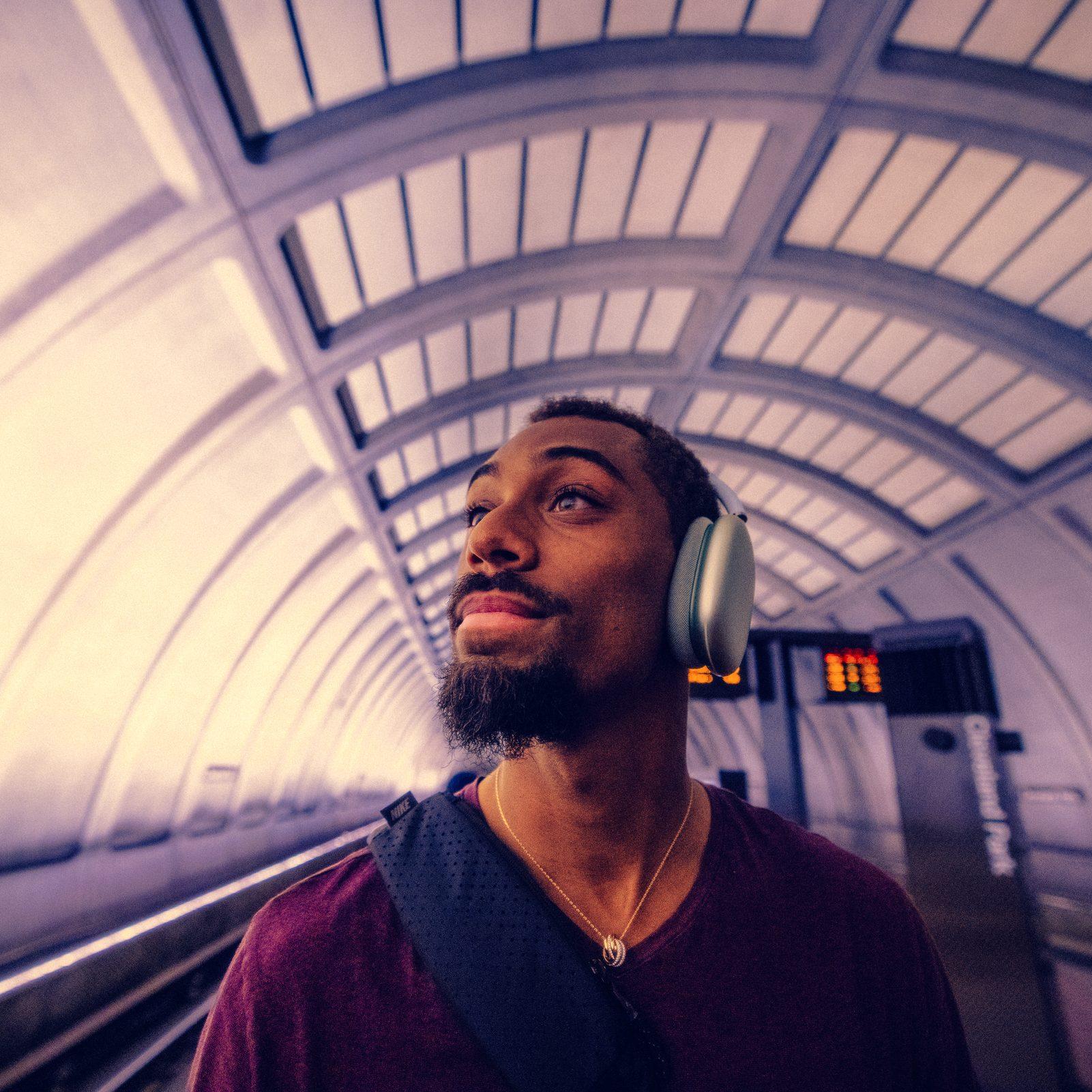Man wearing headphones on a subway platform