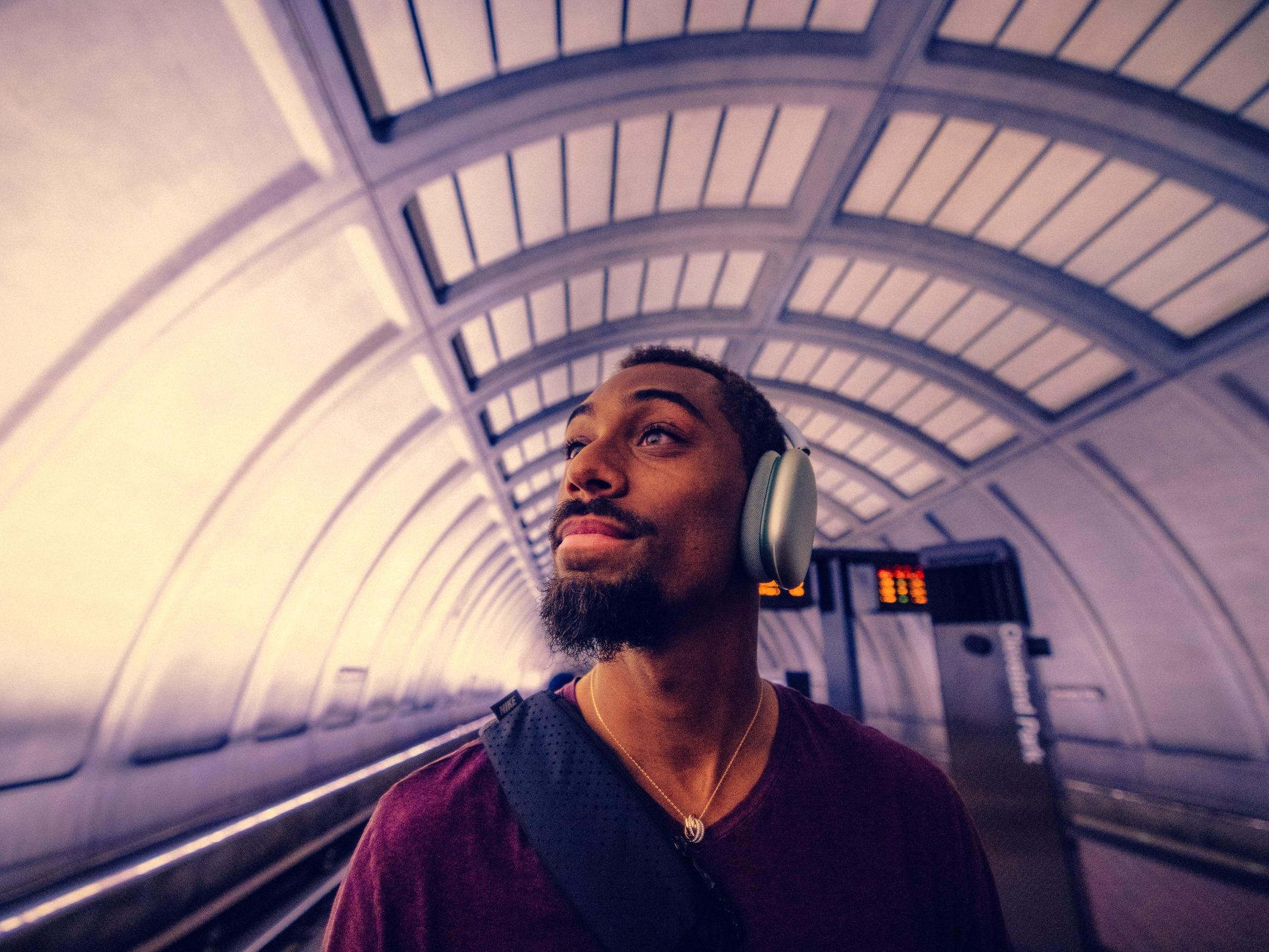 Man wearing headphones on a subway platform