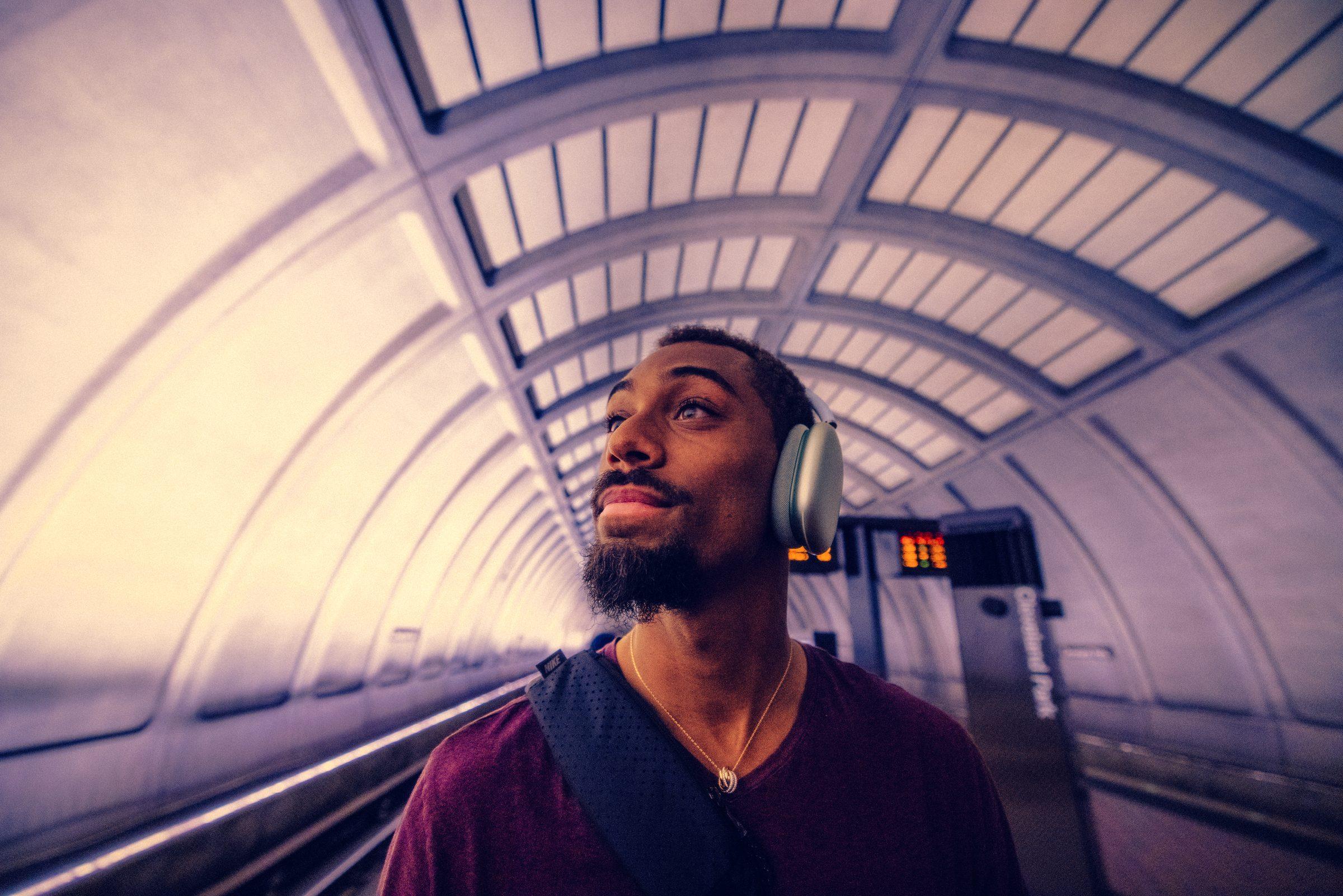 Man wearing headphones on a subway platform