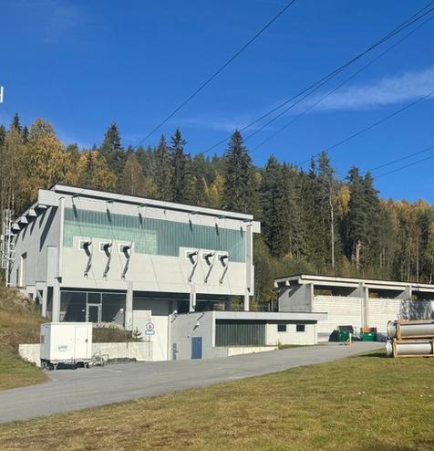 Kraftverk, vei, skog, gress, himmel. Foto.