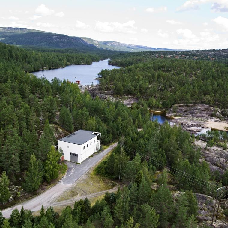 Kraftverk, vann, skog. Foto.