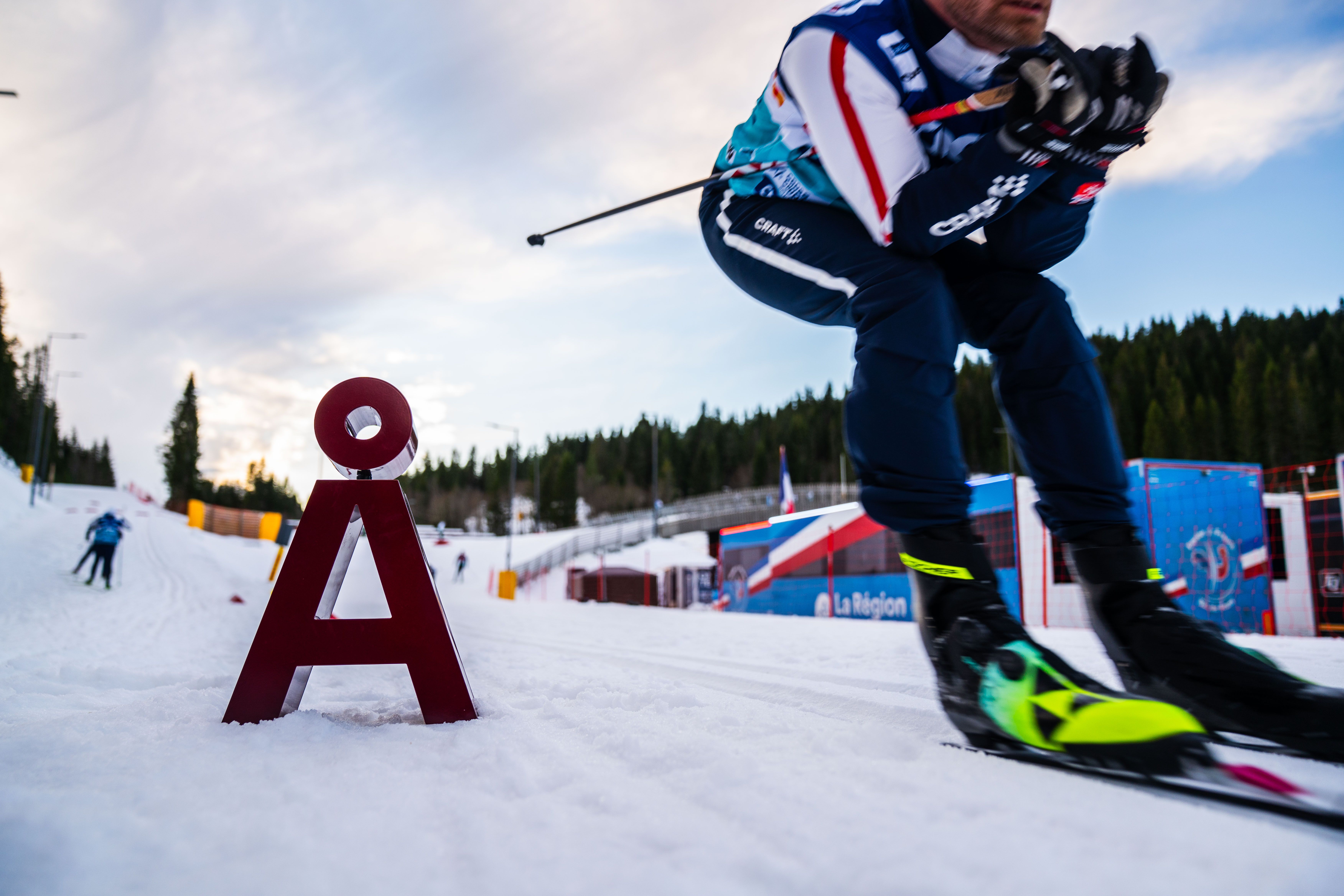 Skiløper forbi en Å i snøen