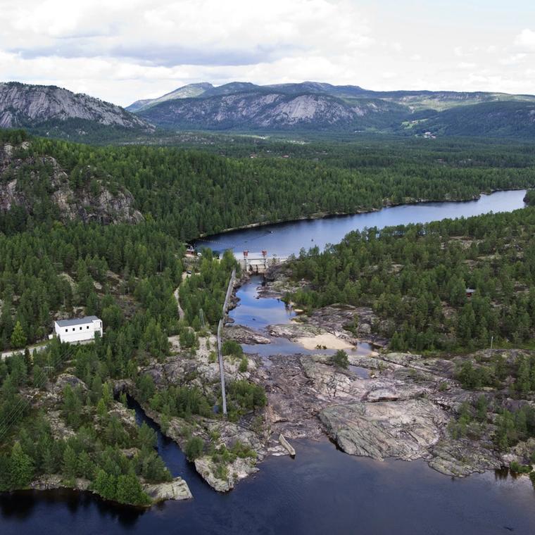 Kraftverk, vann, skog. Foto.