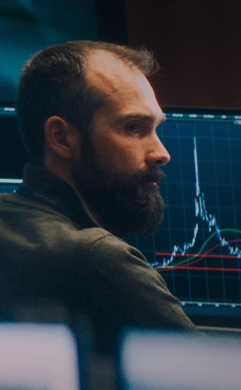 Mann ved pc-skjermer. Foto.