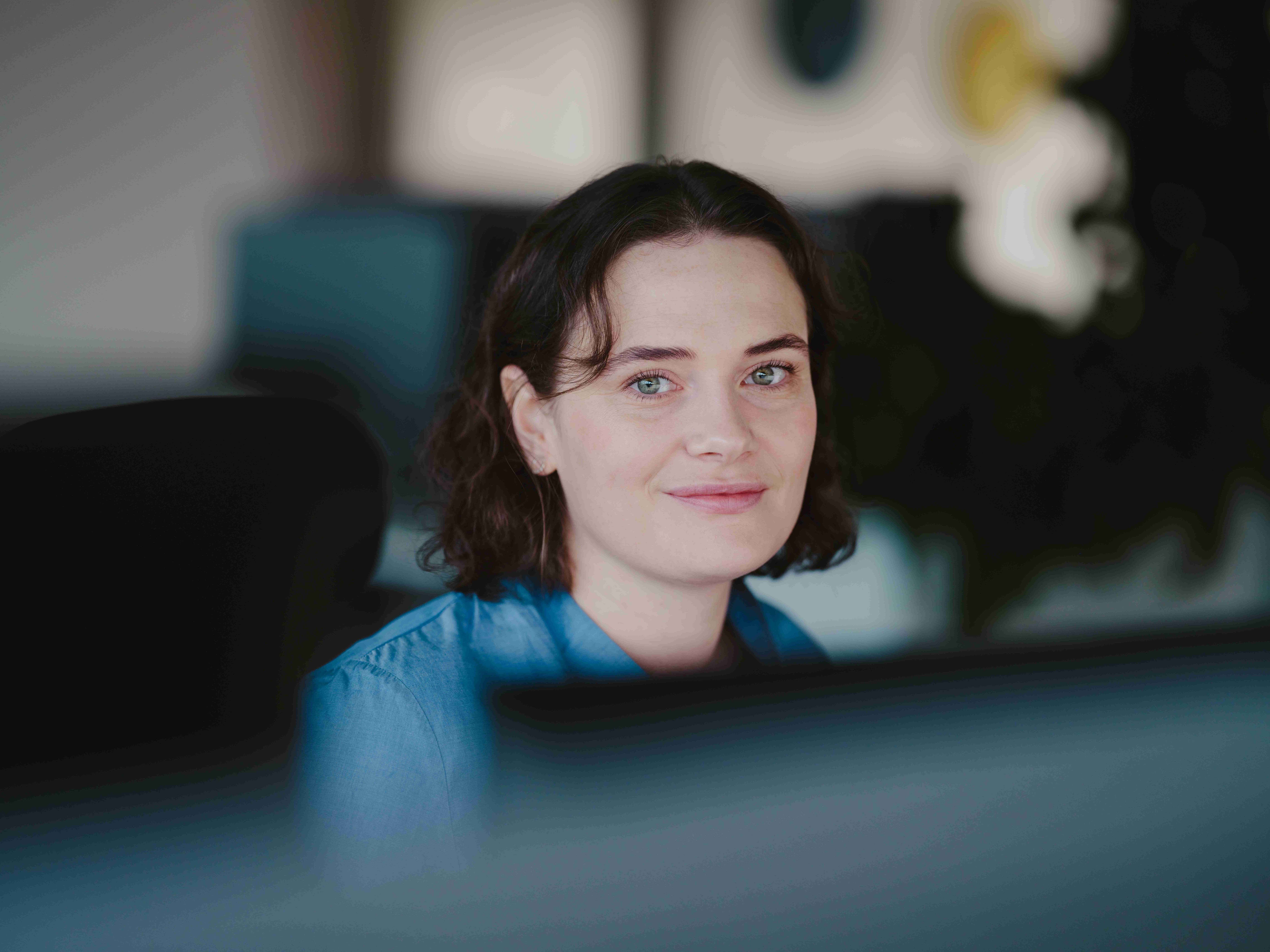 Kvinne ser i kamera på kontor