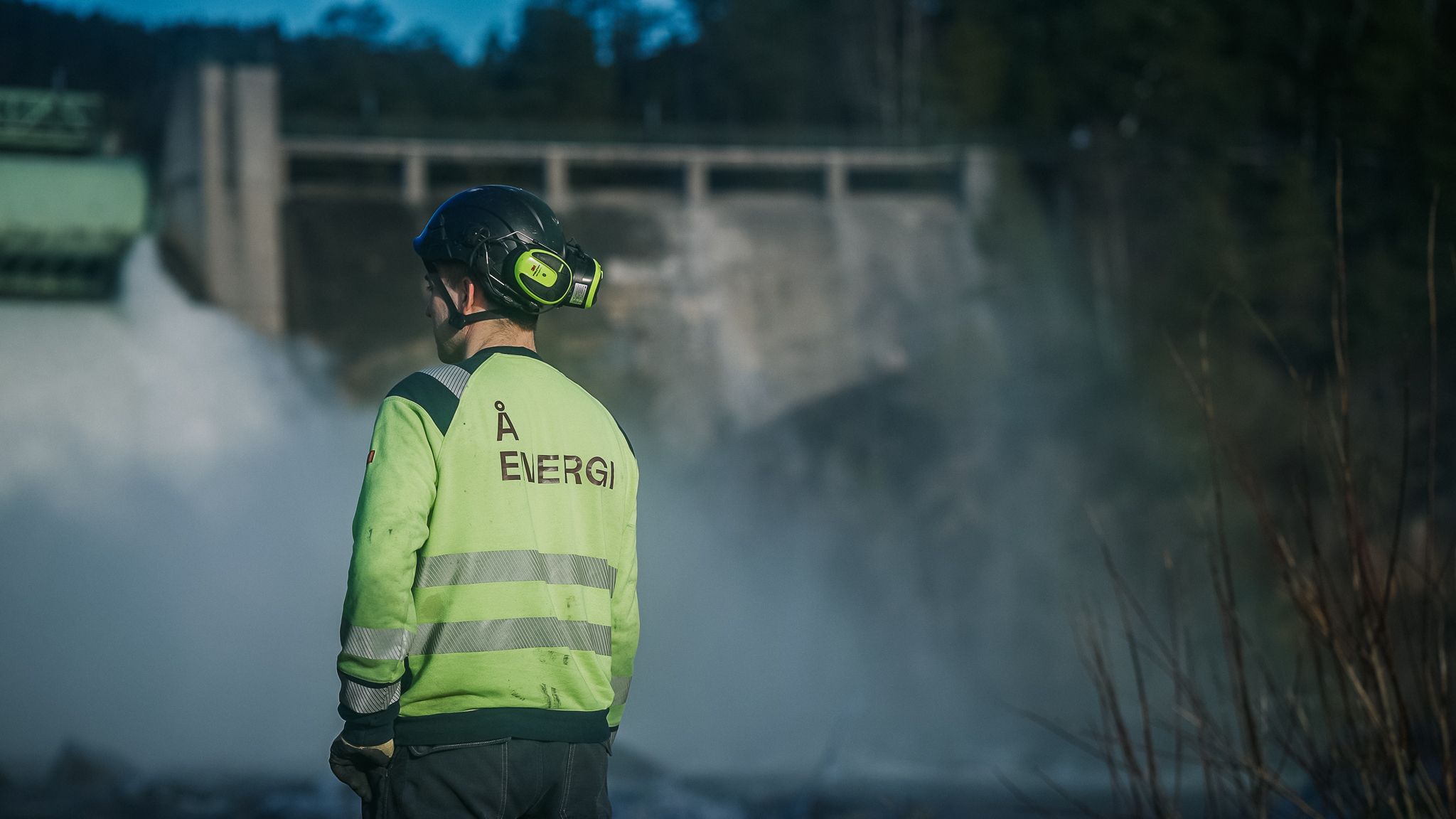 Vannkraft, dam, mann i vernetøy. Foto. 