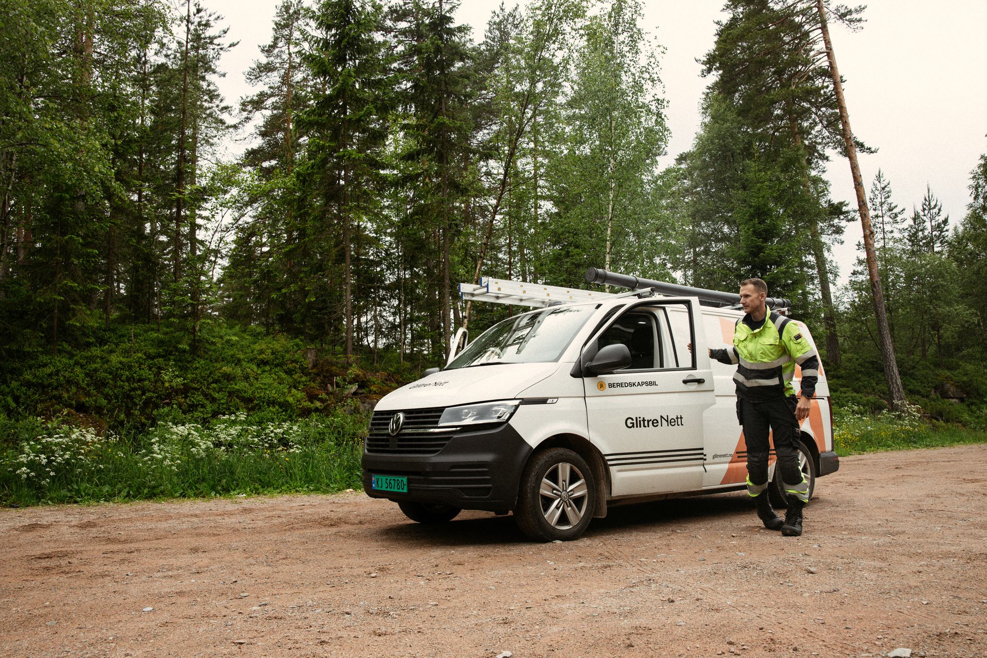 Energimontør og beredskapsbil med skog i bakgrunnen