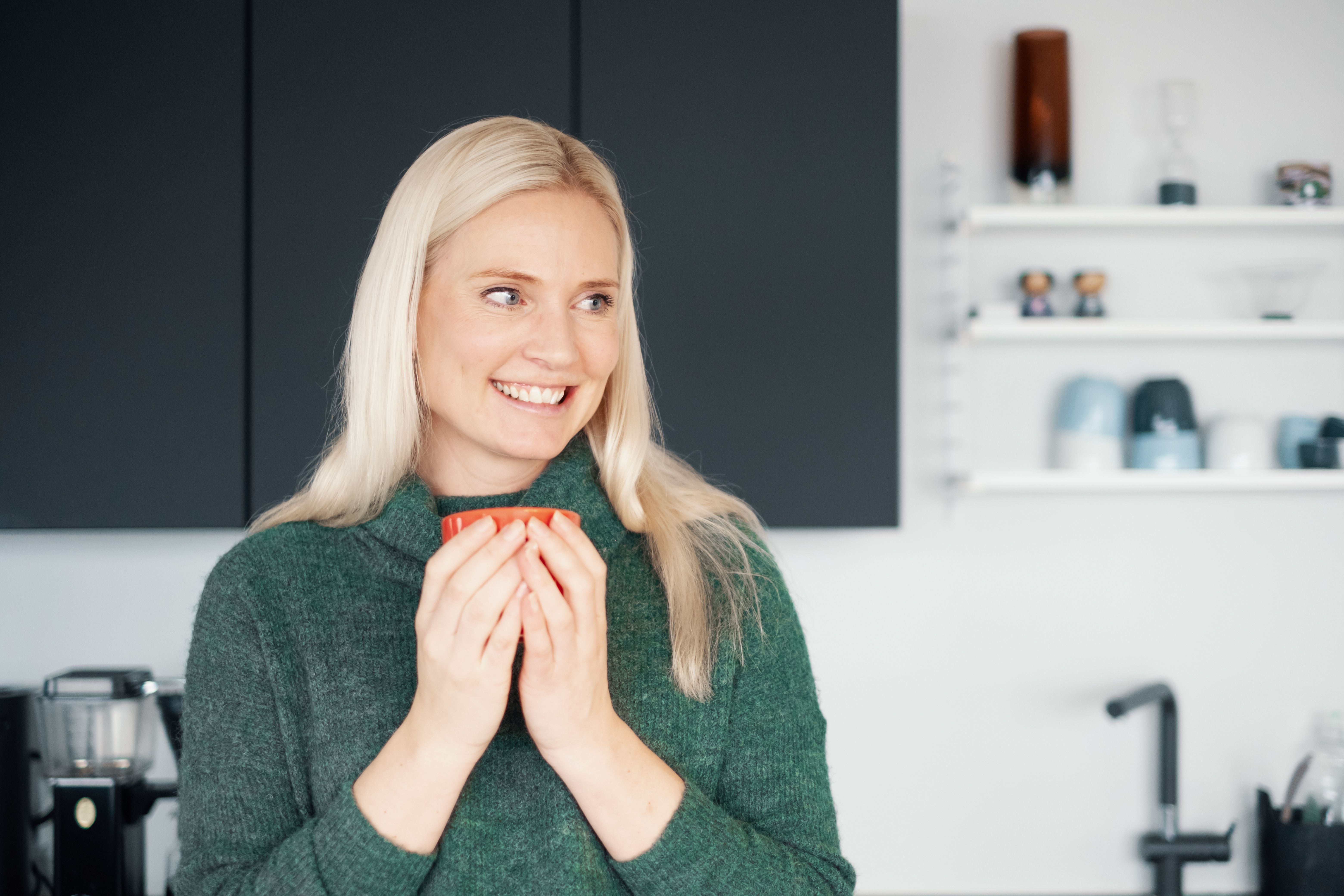 Dame med kaffekopp på kjøkkenet