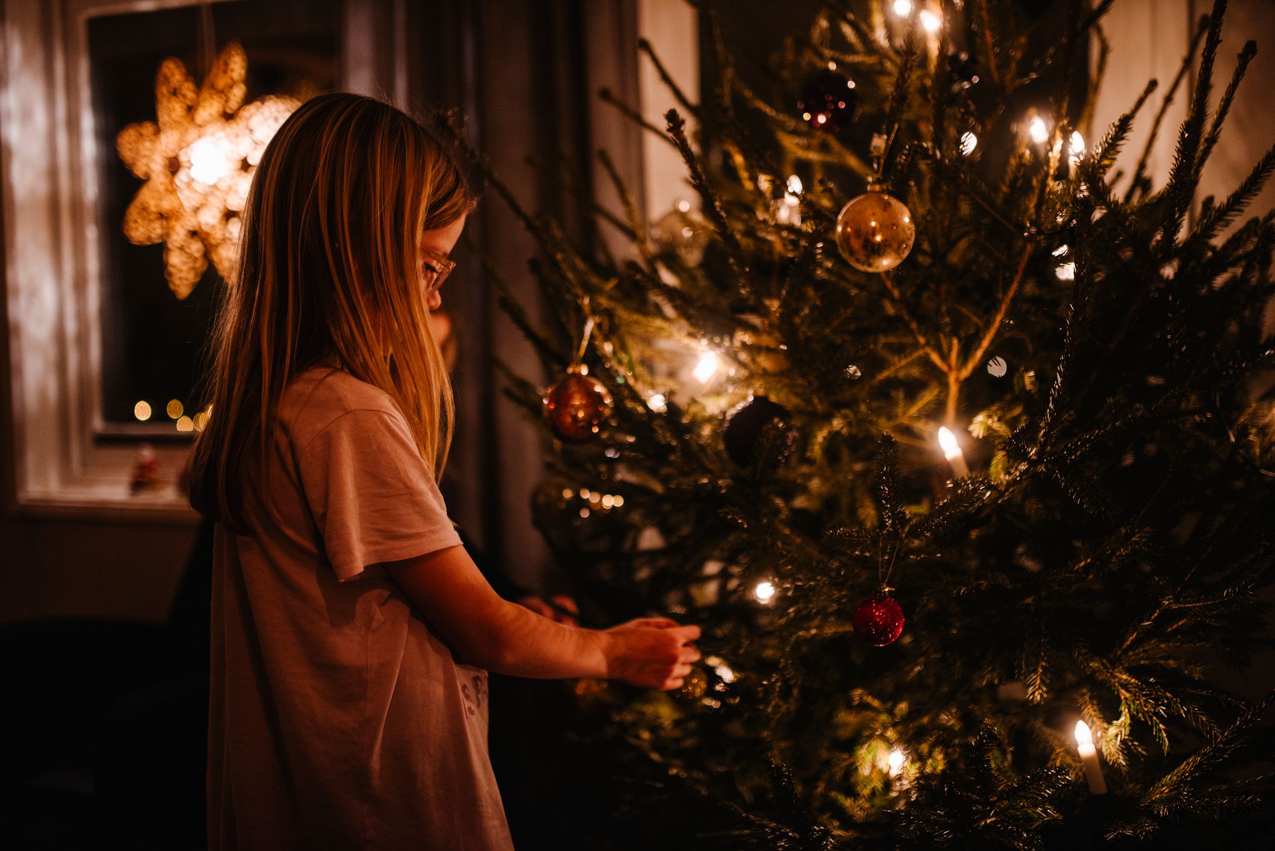 Jente som pynter juletre