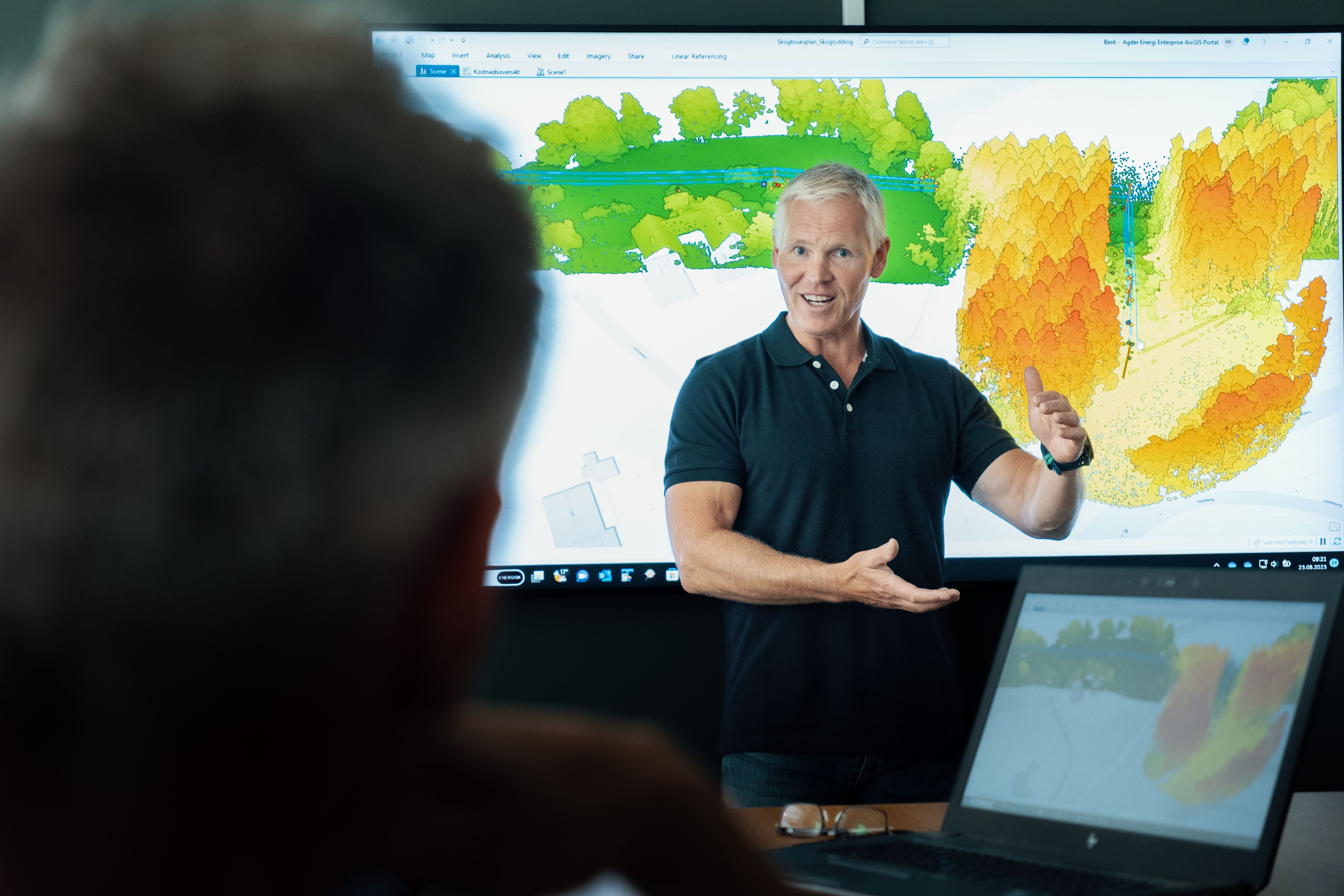 Mann foran stor skjerm med datakart av skog