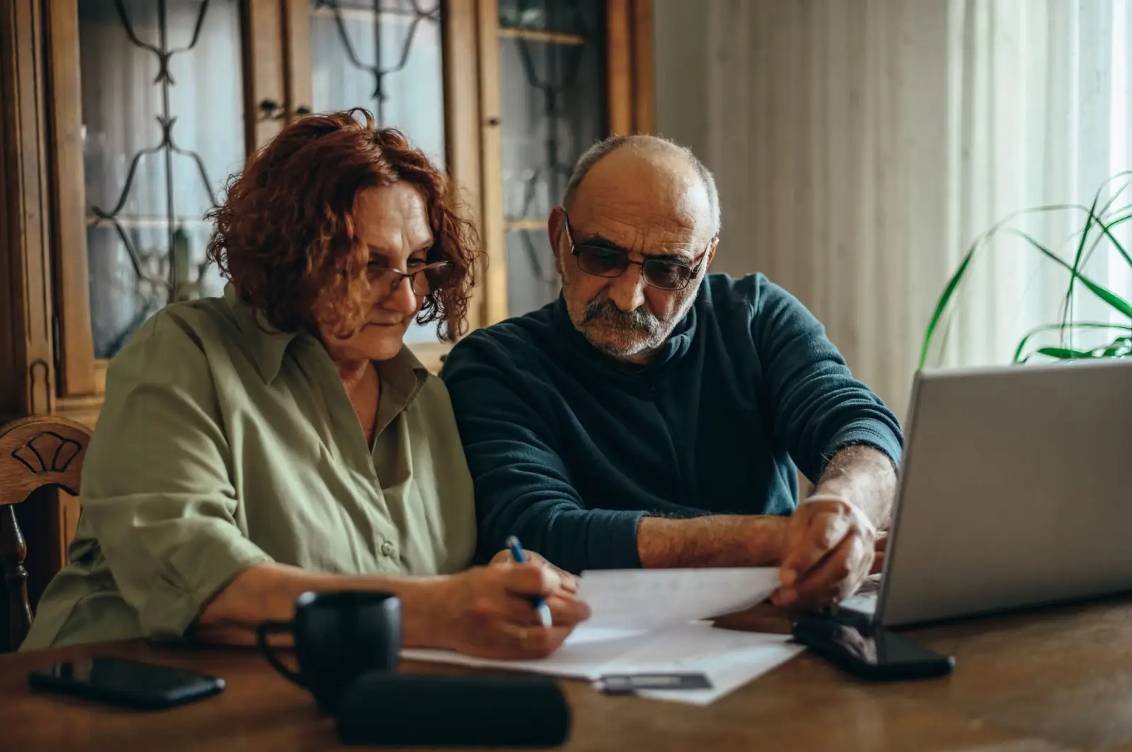 Older woman and man sitting down looking at finances