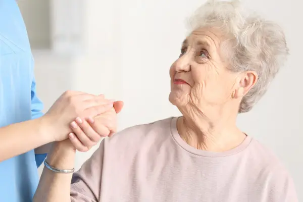 Person holding elderly woman's hand