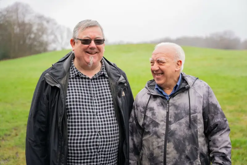 Two elderly people walking in the park