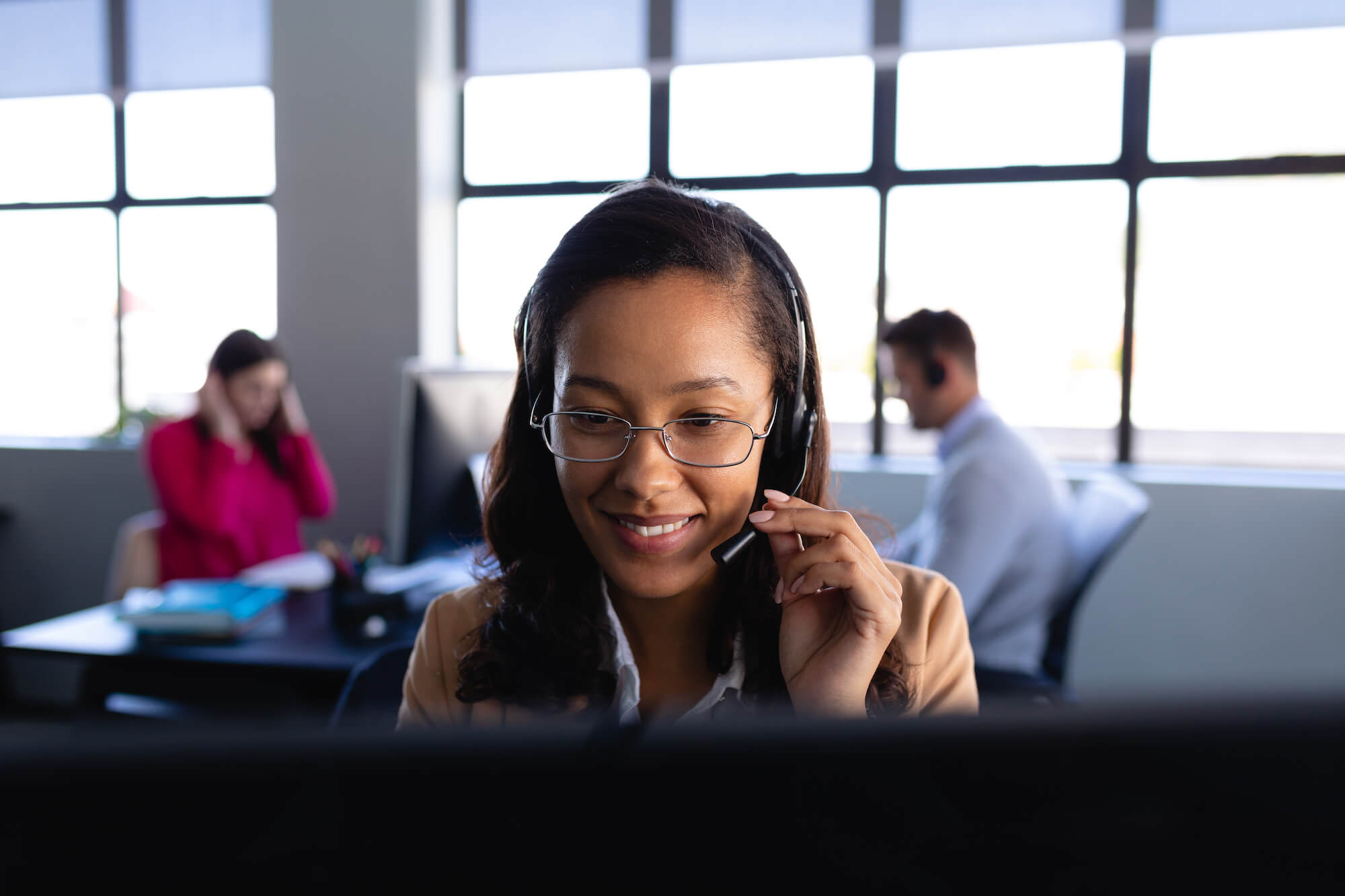 A woman answering a call while holding her headphones