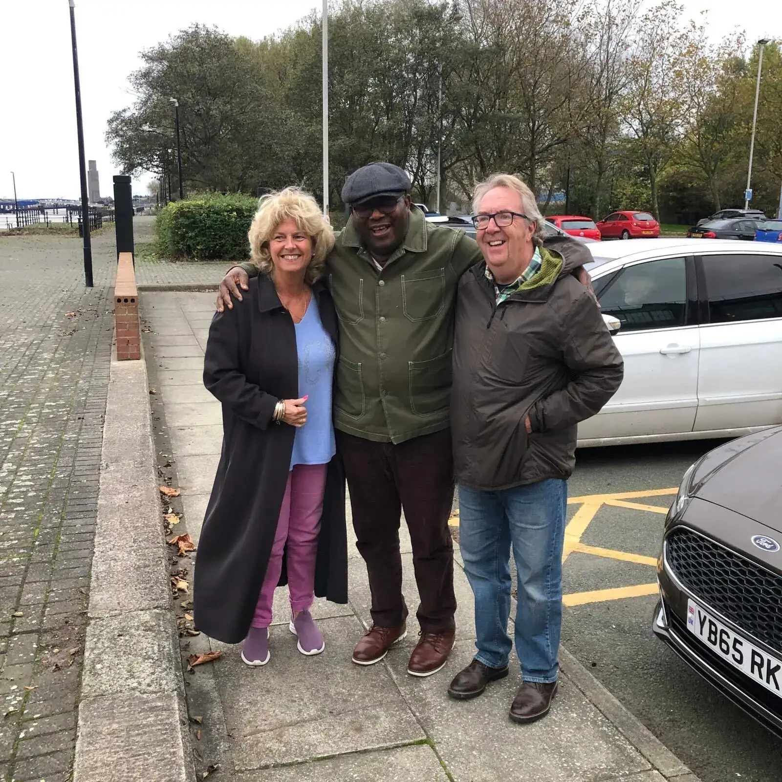 Mike and his wife Sue with their carer Godswill