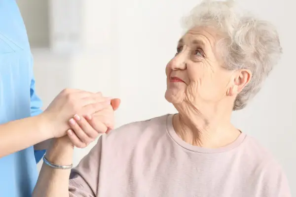 Elderly woman being held by her carer