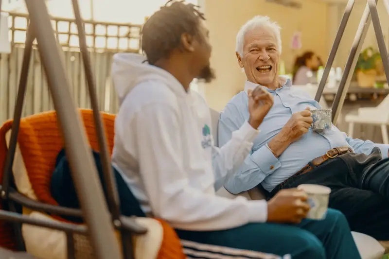 Elderly man having a cup of tea with his carer