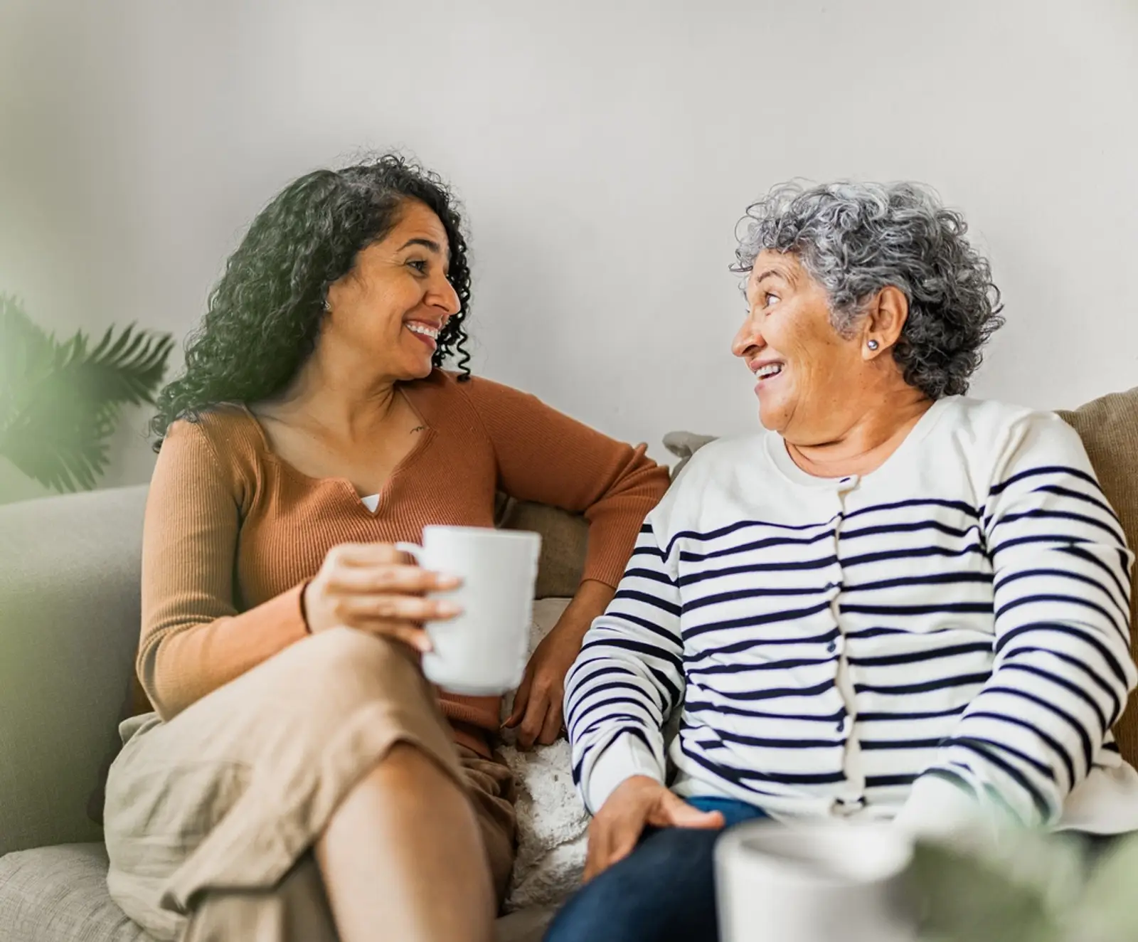 Carer sitting on couch speaking with elderly lady