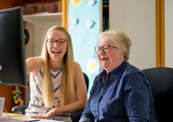 Elderly woman looking at screen with her granddaughter