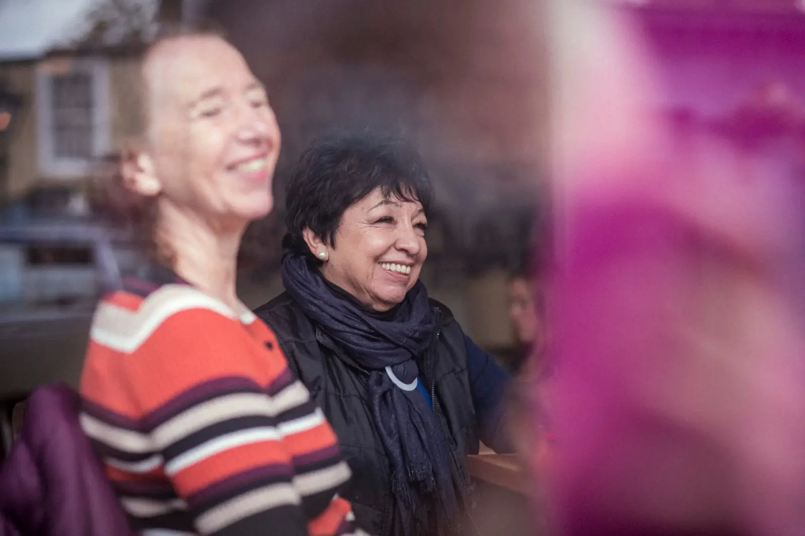 Live-in carer and care recipient smiling in cafe