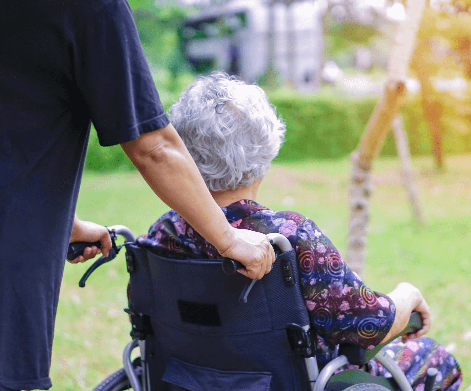 Nurse assisting elderly woman in a wheelchair
