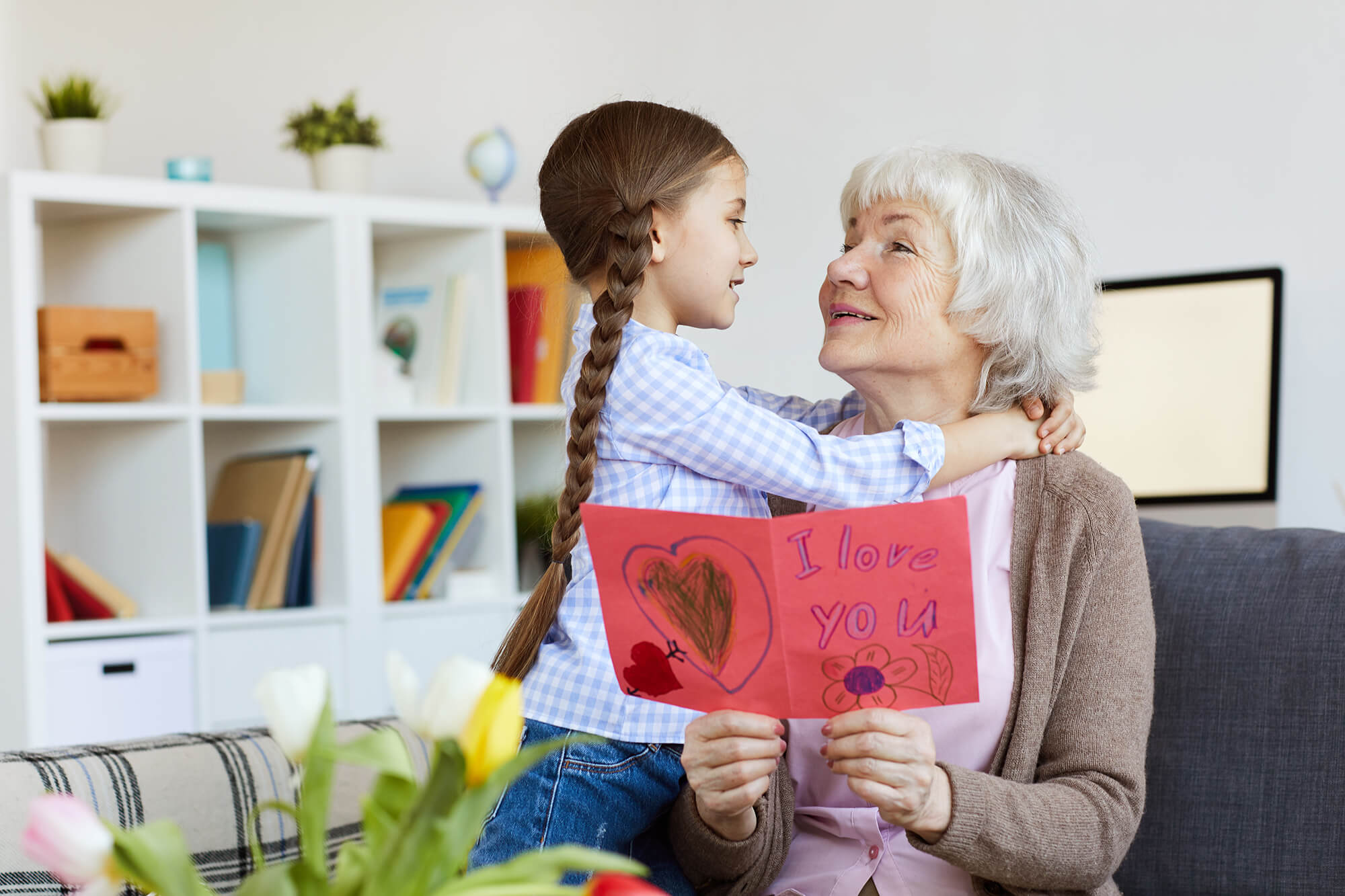 Elderly woman with her granddaughter holding a card