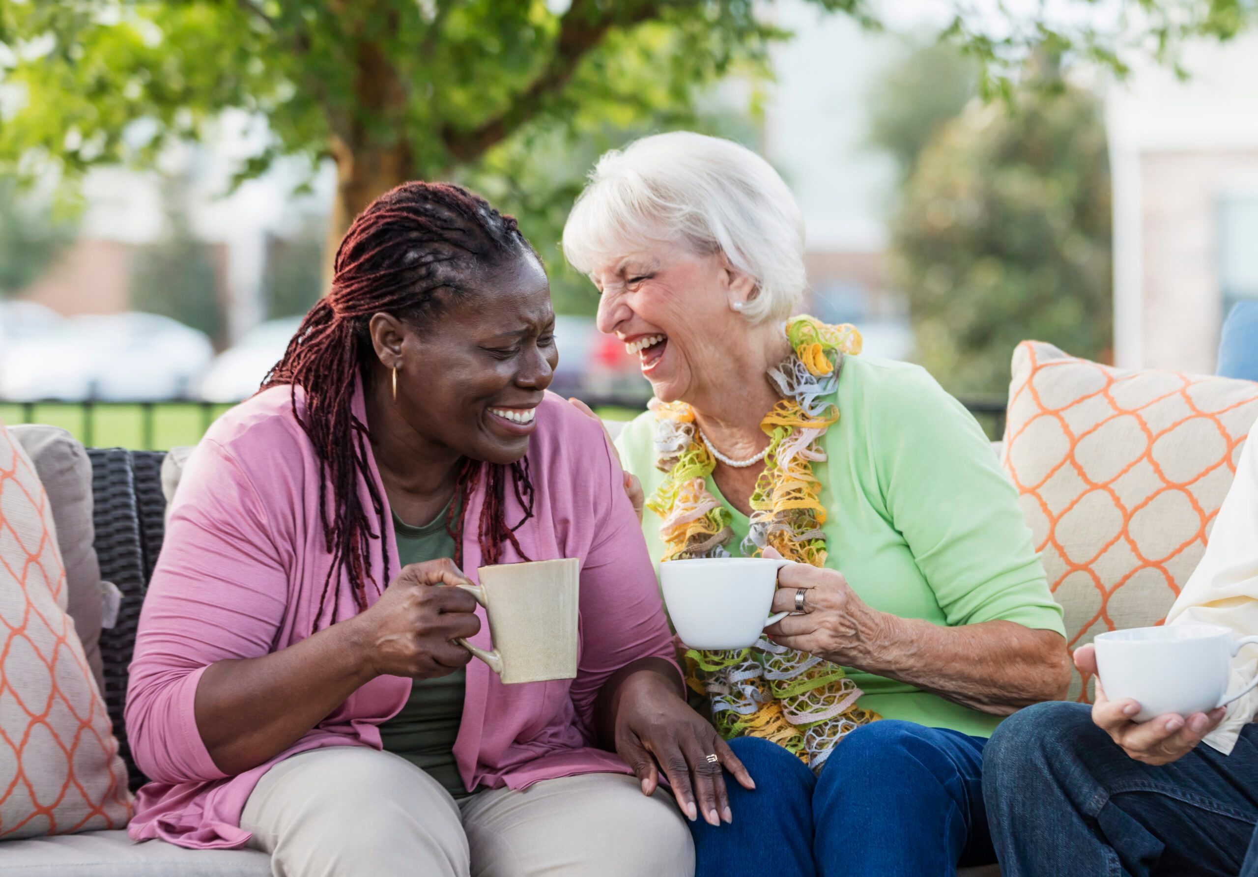 A carer and client laughing and drinking tea
