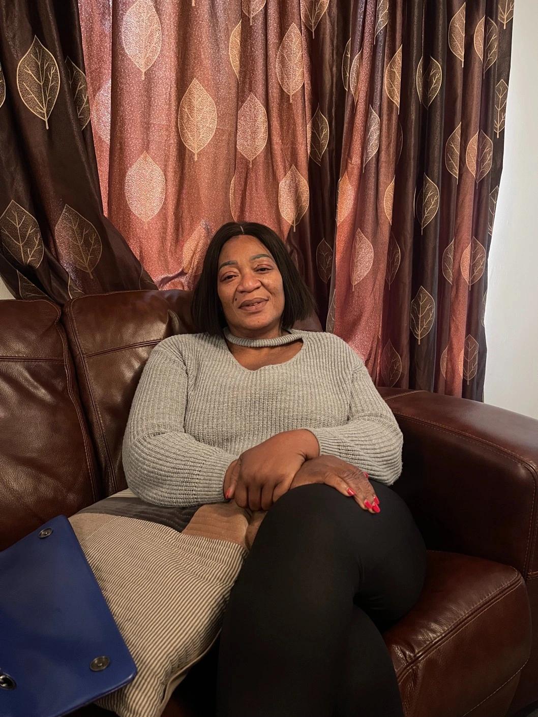 Carer Yemi sitting on the sofa