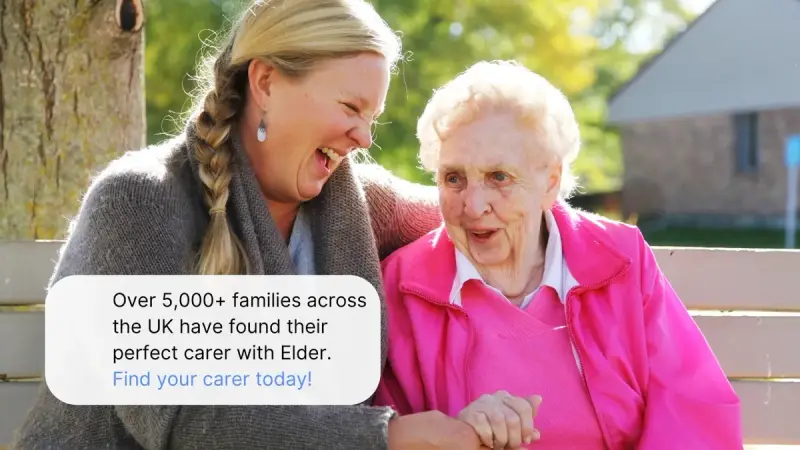 Carer and recipient laughing on a bench
