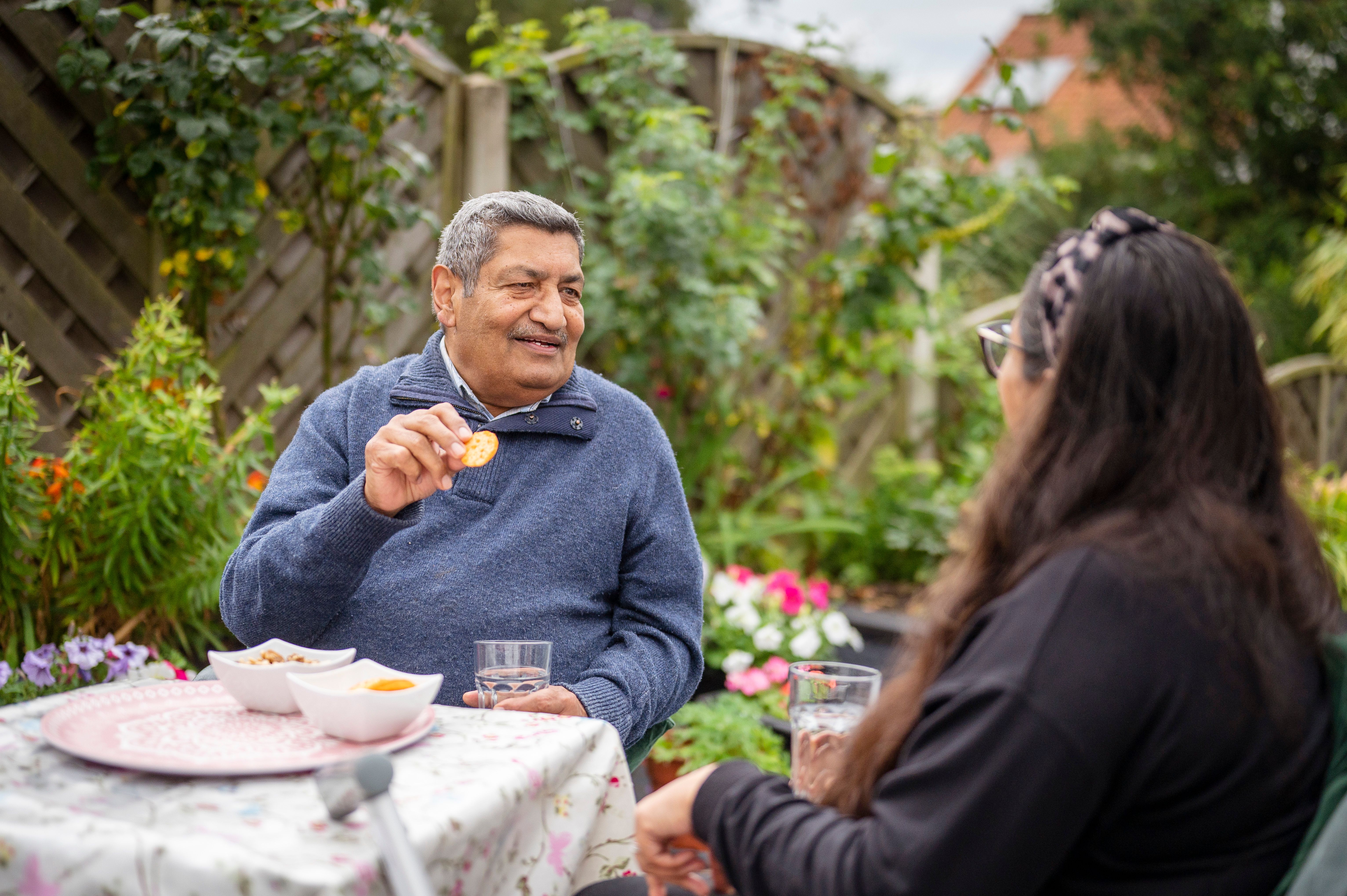 Man and woman sitting in the garden whilst in conversation