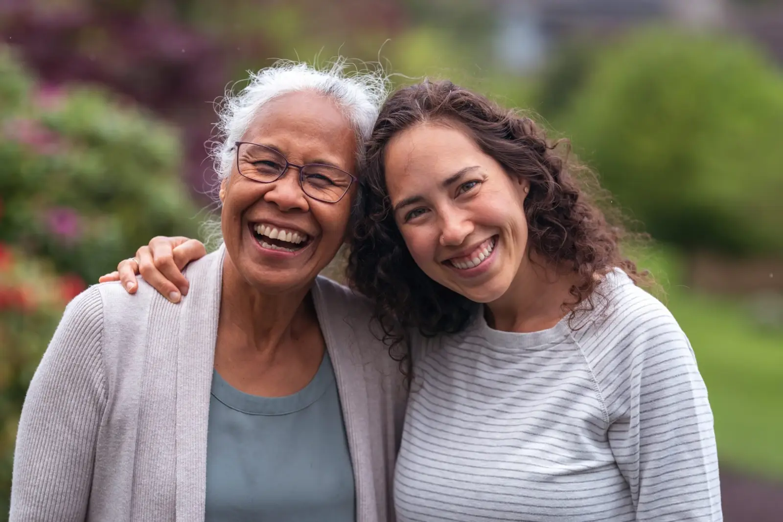Elderly woman and younger woman embrace