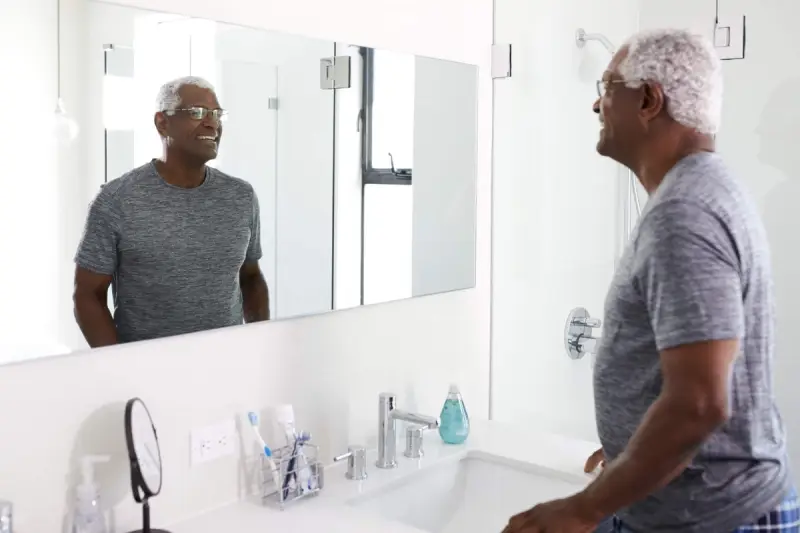 Elderly man looking at mirror
