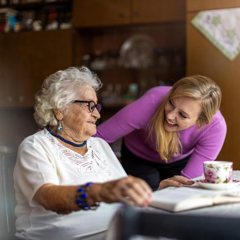 Elderly woman smiling with her carer