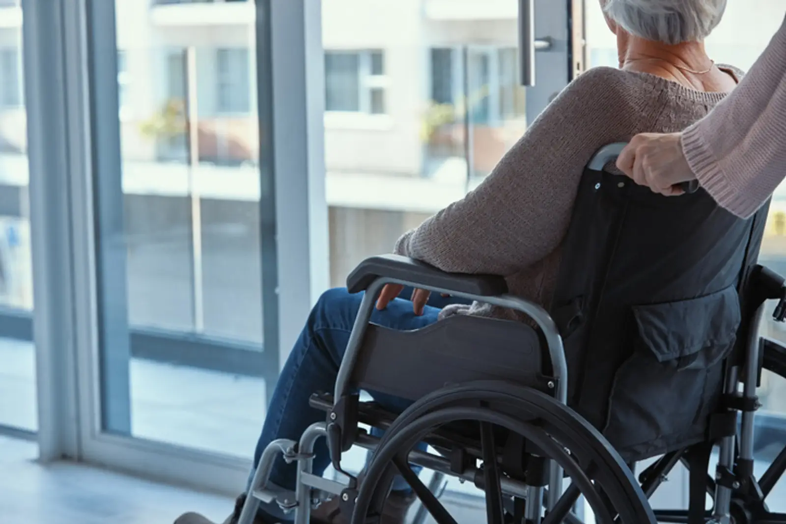 Elderly person in wheelchair leaving hospital