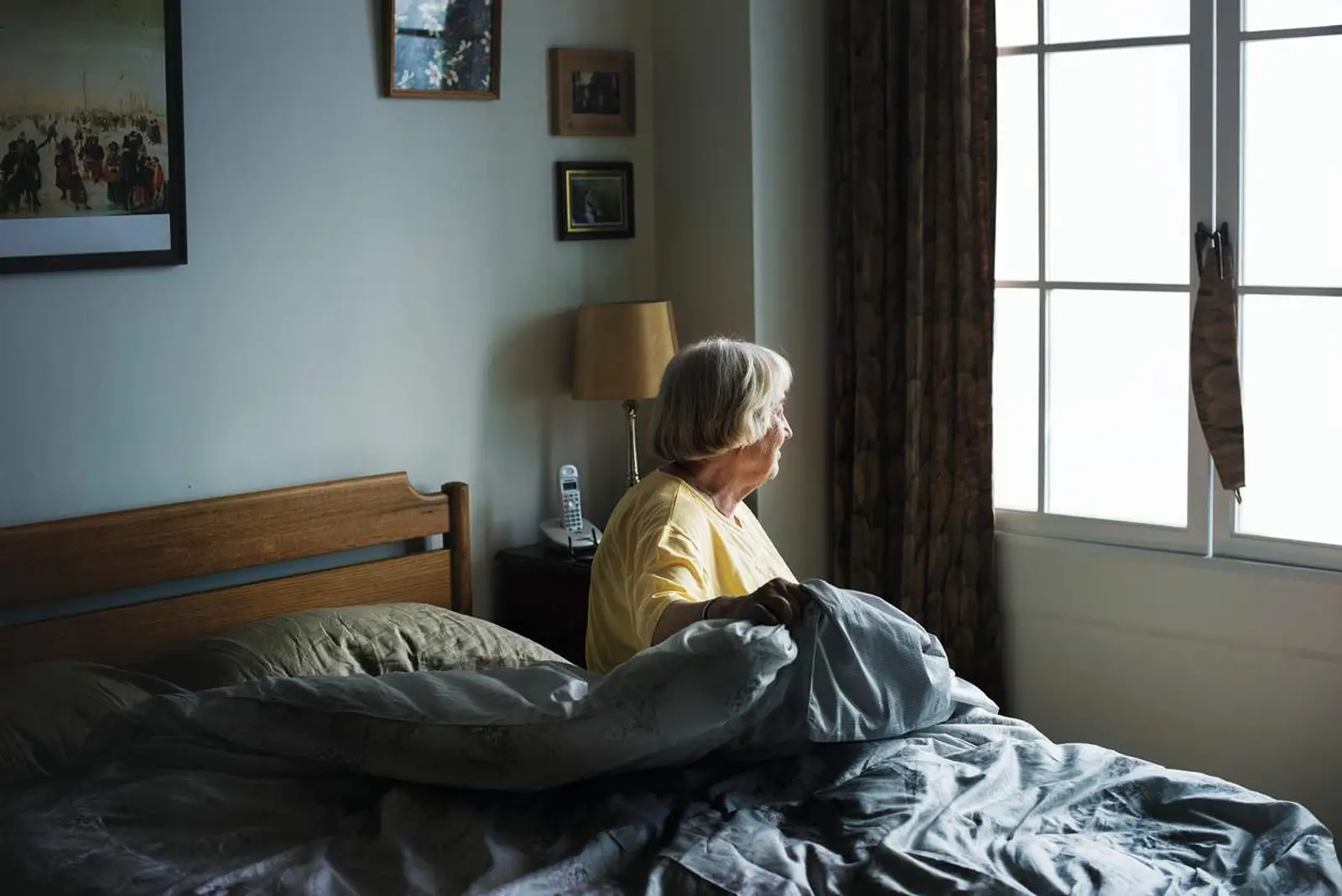 Elderly women getting out of bed at home