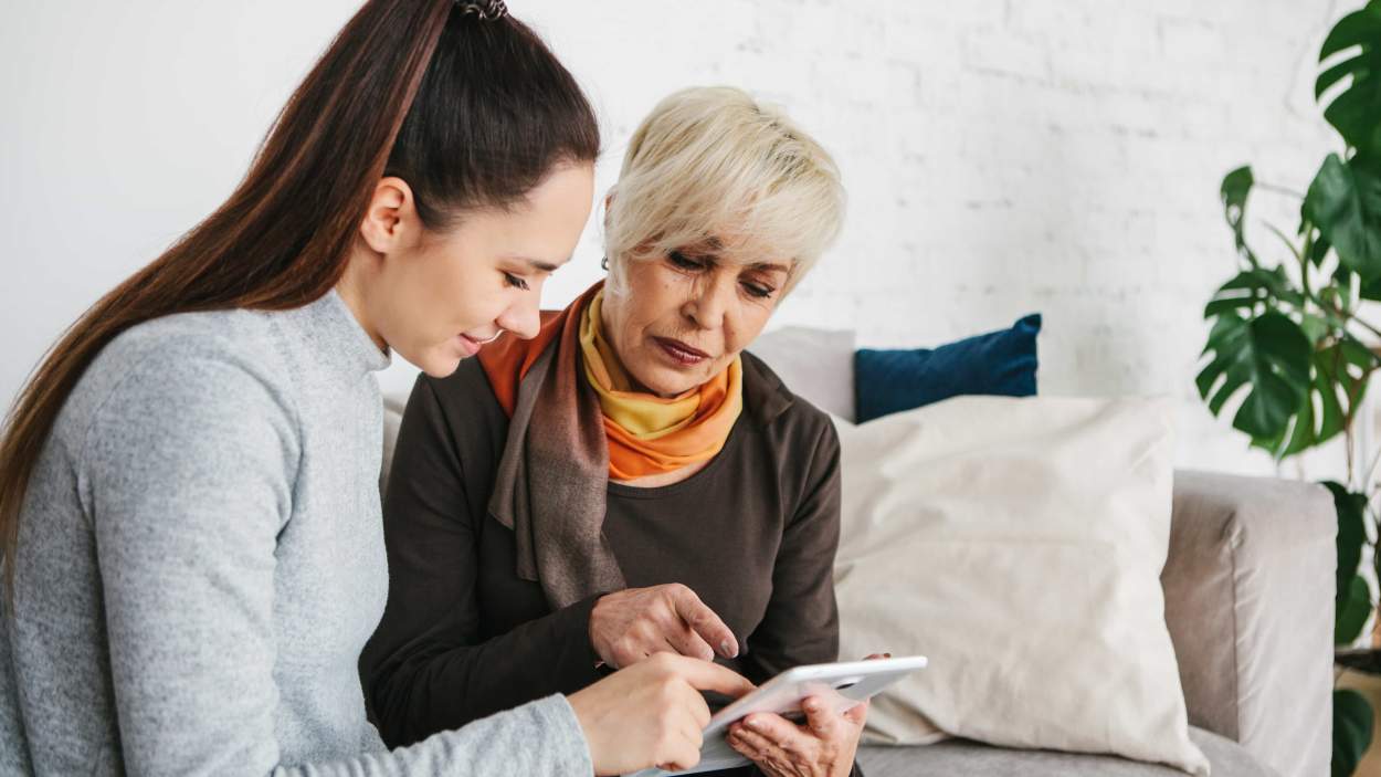 Young woman with older person looking at ipad