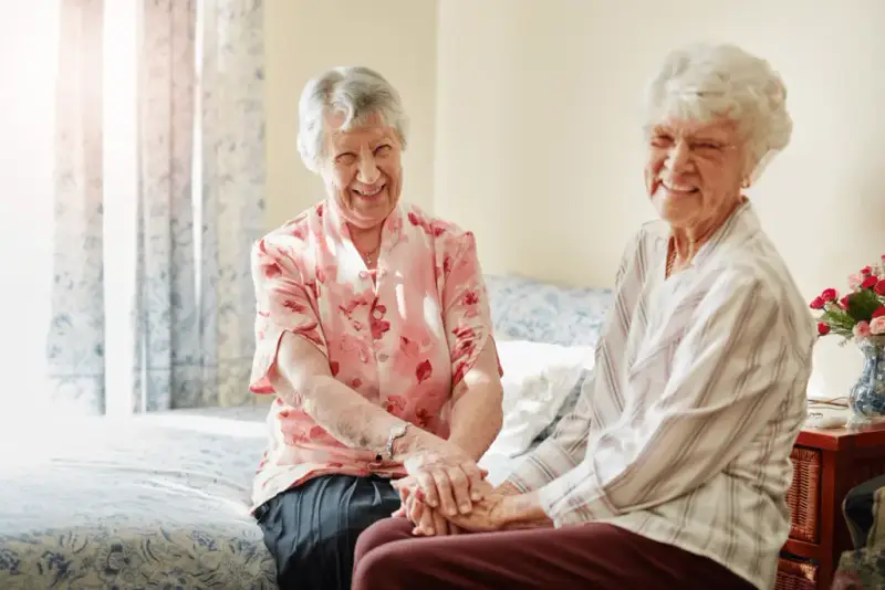 Two elderly women at home smiling