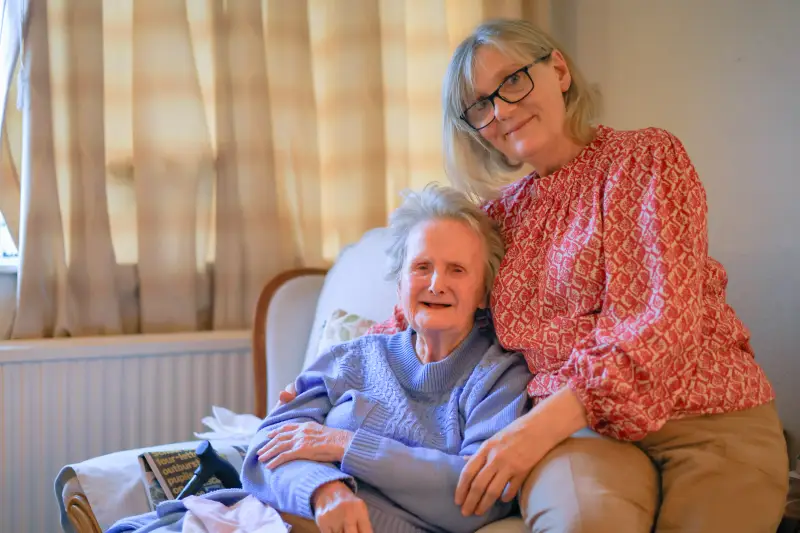 Elderly woman sitting with her carer