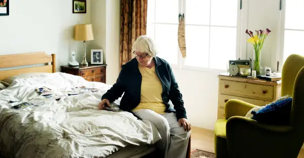 Older woman sitting on her bed