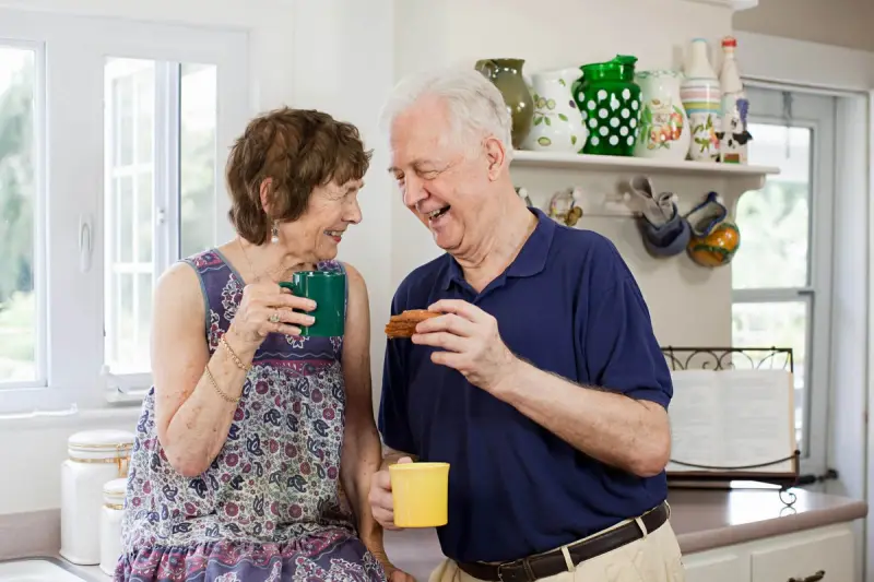 Elderly couple smiling and drinking tea
