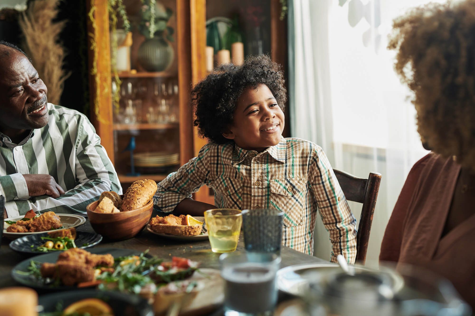 Little boy having family dinner with parents