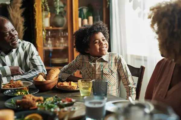 Little boy having family dinner with parents