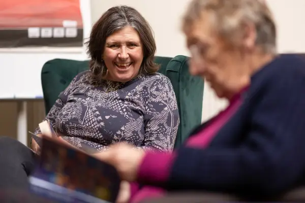 Two elderly women sitting and reading books