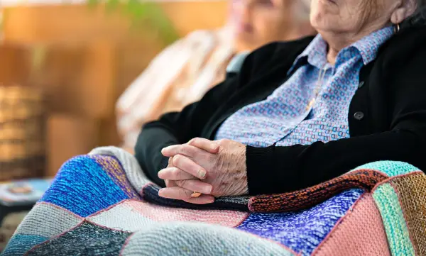Older woman sitting with a blanket