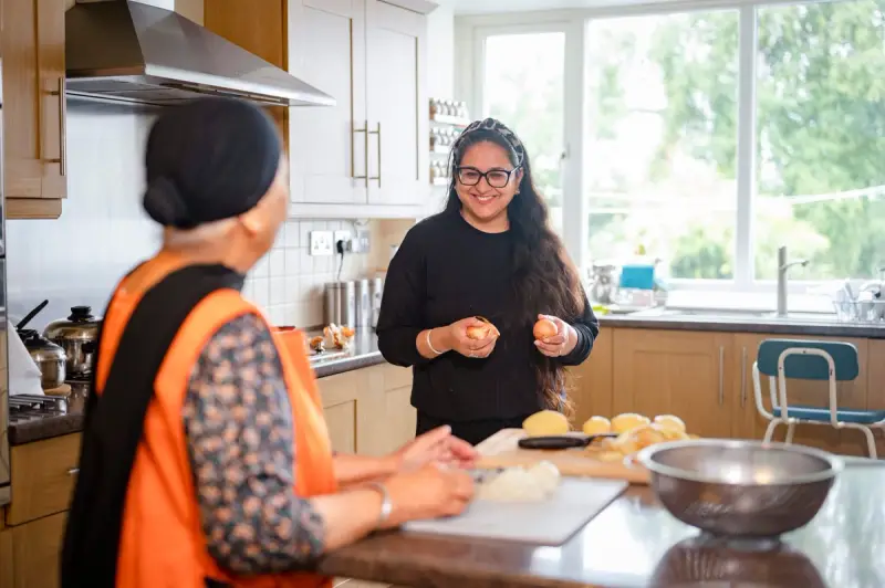Carer helping elderly woman in the kitchen