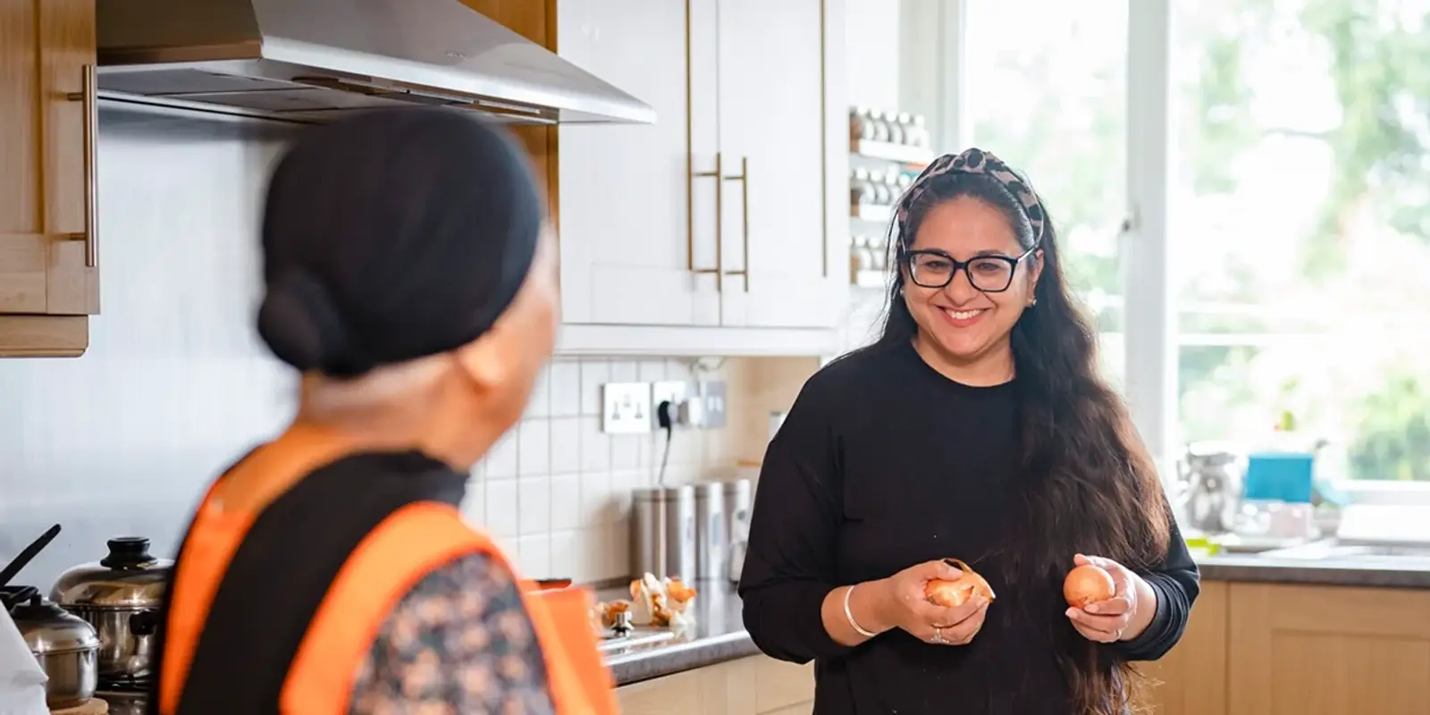 Carer helping elderly woman in the kitchen